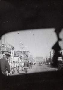 View from rear window of a car of troops marching, Qianmen Street, Peking