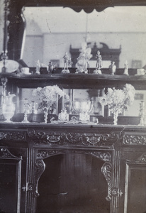 A mirrored sideboard with figurines and chrysanthemums