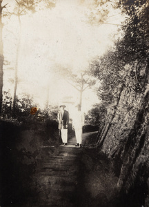 Two men standing in a shady road