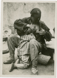 A woman, wounded by Japanese soldiers, breastfeeding a child