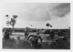 Eighth Route Army soldiers carging towards Japanese soldiers behind grave mounds, Central Hebei