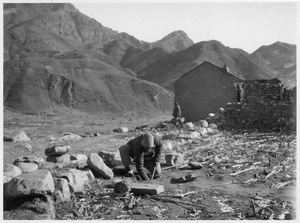 A man laying a landmine beside a road