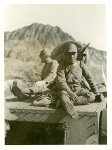 Japanese soldiers sitting on top of an armoured vehicle