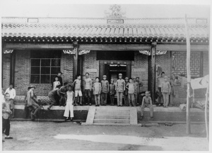 Children pose for a photograph outside a building