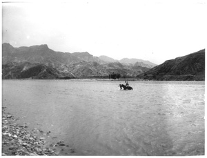 A man on horseback and another man fording the Sha River at Fuping, 1938