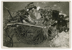 Pile of ammunition, boots, wires, bottles, a rifle, and a sword - likely captured Japanese kit