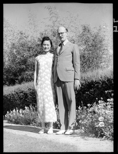 Hsiao Li Lindsay (李效黎) and Michael Lindsay (林迈可) beside a flower bed and hedge
