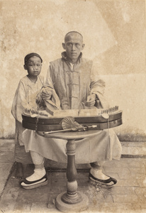 A musician and a boy, with a yang qin (""foreign zither"") and small bagpipes