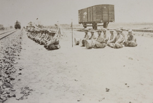 General Mei's military band and soldiers sitting beside railway tracks