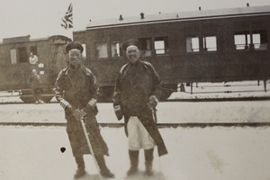 Two of General Mei's officers in front of a railway carriage flying the Union Jack