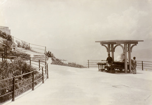 Chinese pedlars under a pavilion beside a road leading up the mountain, possibly the Peak, Hong Kong