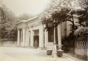Man with a carrying pole in front of the entrance to Government House, Hong Kong