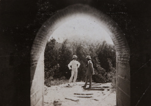 Two men viewed through an archway