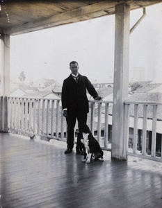 Oliver Heywood Hulme and a dog on a veranda, Anqing (安庆）