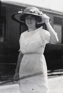 Mary Elizabeth Hulme wearing a wide brimmed hat beside a train carriage