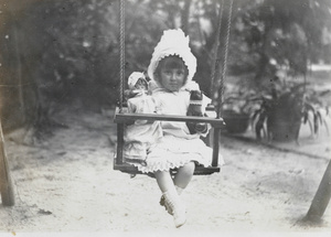 Girl in swing with dolls