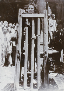 A condemned criminal in a cage, used for slow strangulation, Shanghai