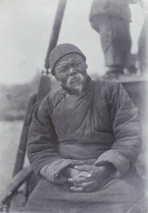An elderly Chinese man on a boat