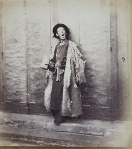 'Old Wang', a night watchman, wearing a sheep-skin coat and with his wooden clapper