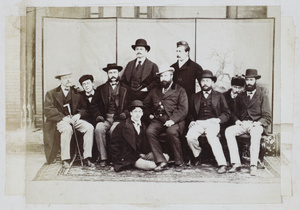 A group of ten men in front of a screen