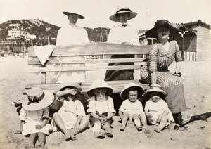 Esme Hutton Potts with children, on the beach, Qingdao