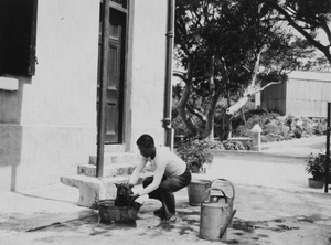 Man washing 'Tam', a pet Scottie dog at Sassoon Villa, Sassoon Road, Hong Kong