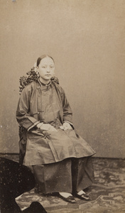 Portrait of a woman wearing shoes that suggest her feet have not been bound