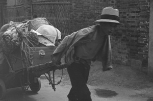 Man pulling cart of possessions, Shanghai