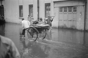 Rickshaws pass through flood waters, Shanghai