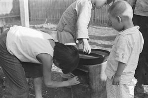 Children tending cooking stove in street, Shanghai