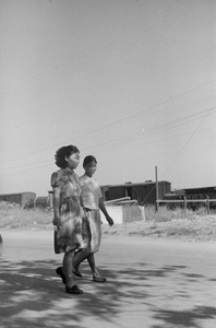 Two women walking near a railway yard