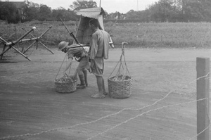 British soldier checking a pedlar's basket, Shanghai