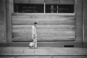 Man walking by boarded up business premises, Shanghai