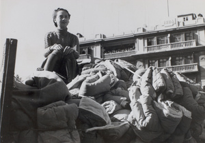 Elsie Lee Soong on a truck loaded with supplies, Shanghai - Belden Apartments behind her