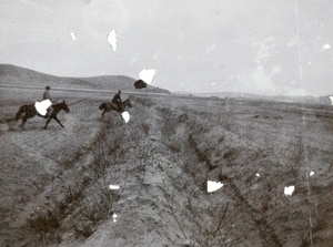Horse riders crossing a field