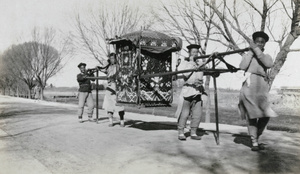 Decorative sedan chair carried by four men