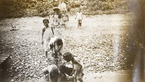 Children looking for coins thrown from a boat