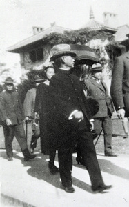 Sun Yat-sen walking past a house