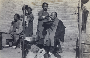 Barbers, appearing to be at work for the camera, Peking