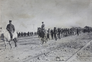 Revolutionary troops marching beside railway tracks