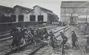 Revolutionary soldiers moving a field gun across railway tracks at a maintenance depot, Hankow