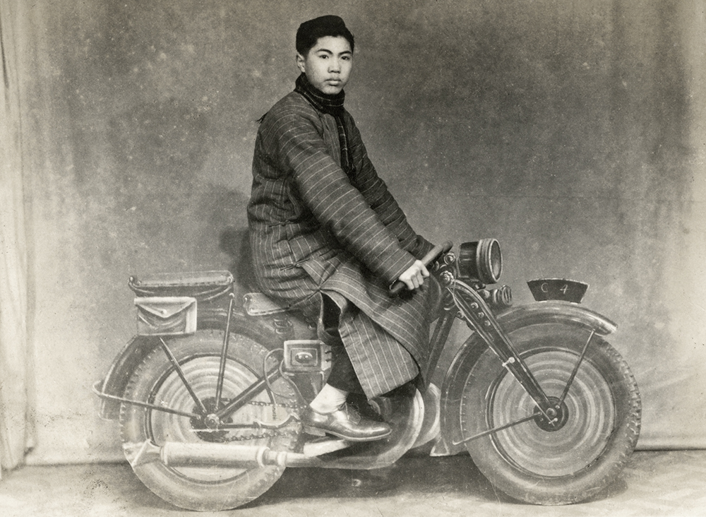 Young man on 'motorbike' in photographer's studio, 1951